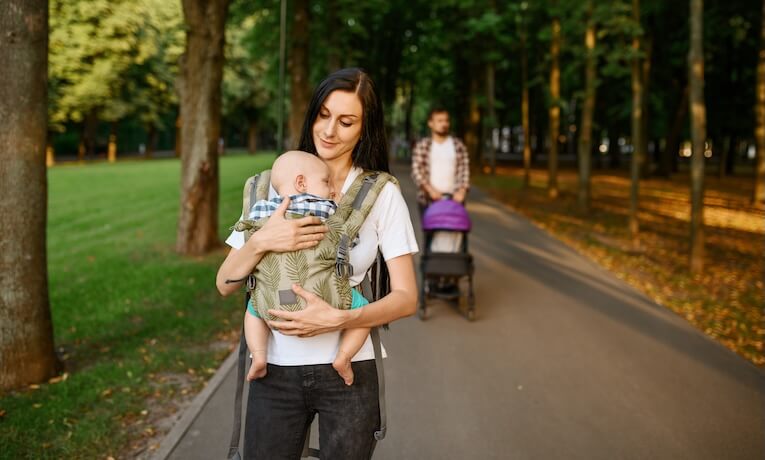 maminka s miminkem v nosítku na procházce
