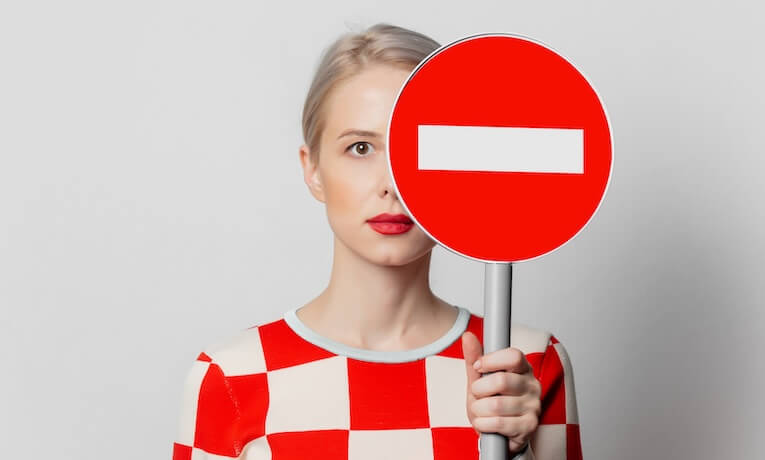 mladá žena drží značku zákaz vjezdu