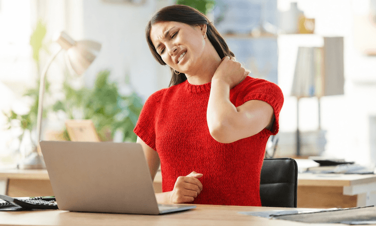 mladá žena pracující na notebooku má bolesti krční páteře