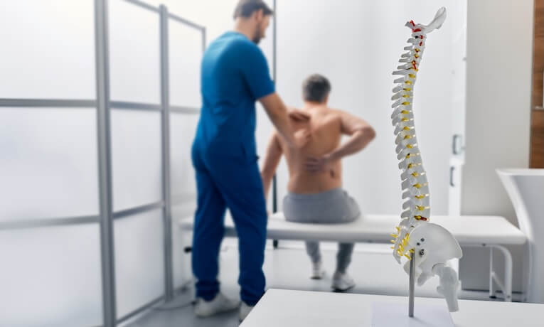lékař vyšetřuje záda muže