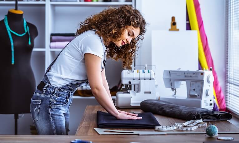 mladá švadlena pracující ve své dílně 