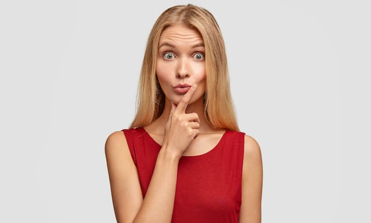 mladá žena s zamyšleným a překvapivým výrazem