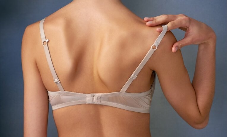 ženská záda bez oblečení, pouze v podprsence