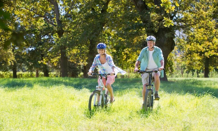 muž a žena jedou na kolech po trávě