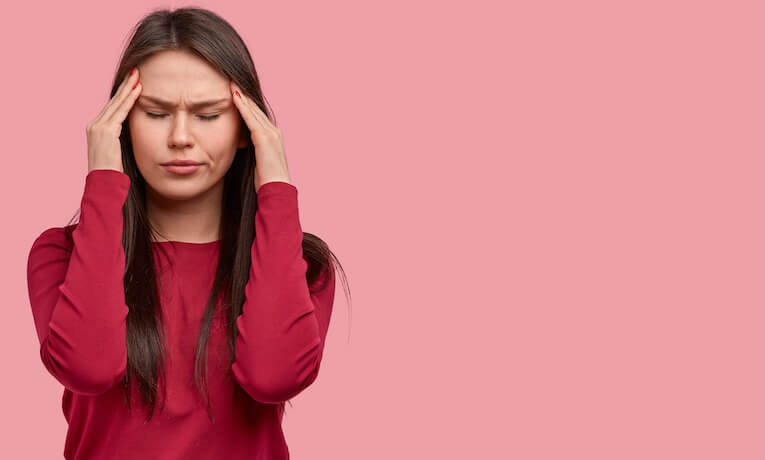 mladá žena s bolestí hlavy