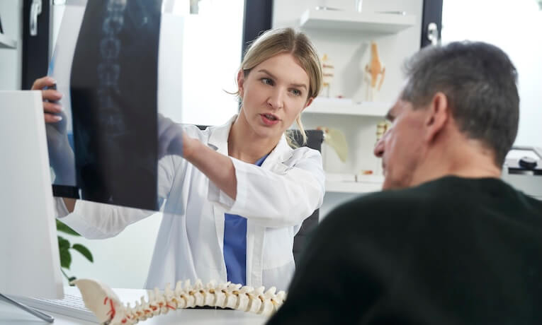 lékařka ukazuje pacientovi RTG snímek