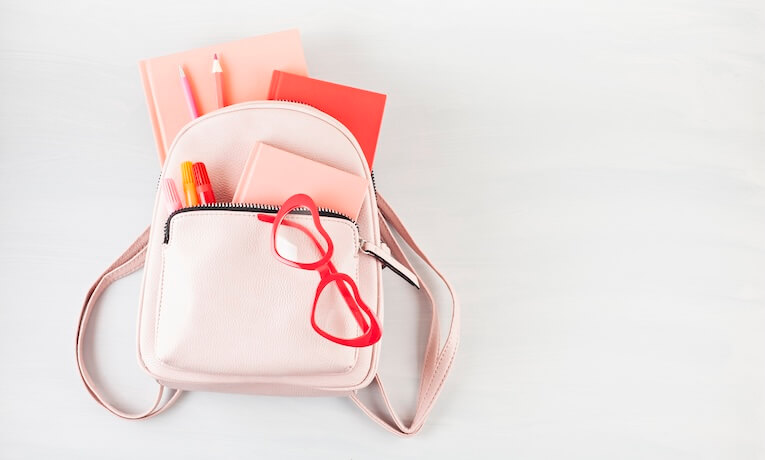 růžový dámský batoh plný věcí