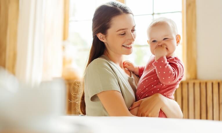 mladá žena s miminkem v náručí
